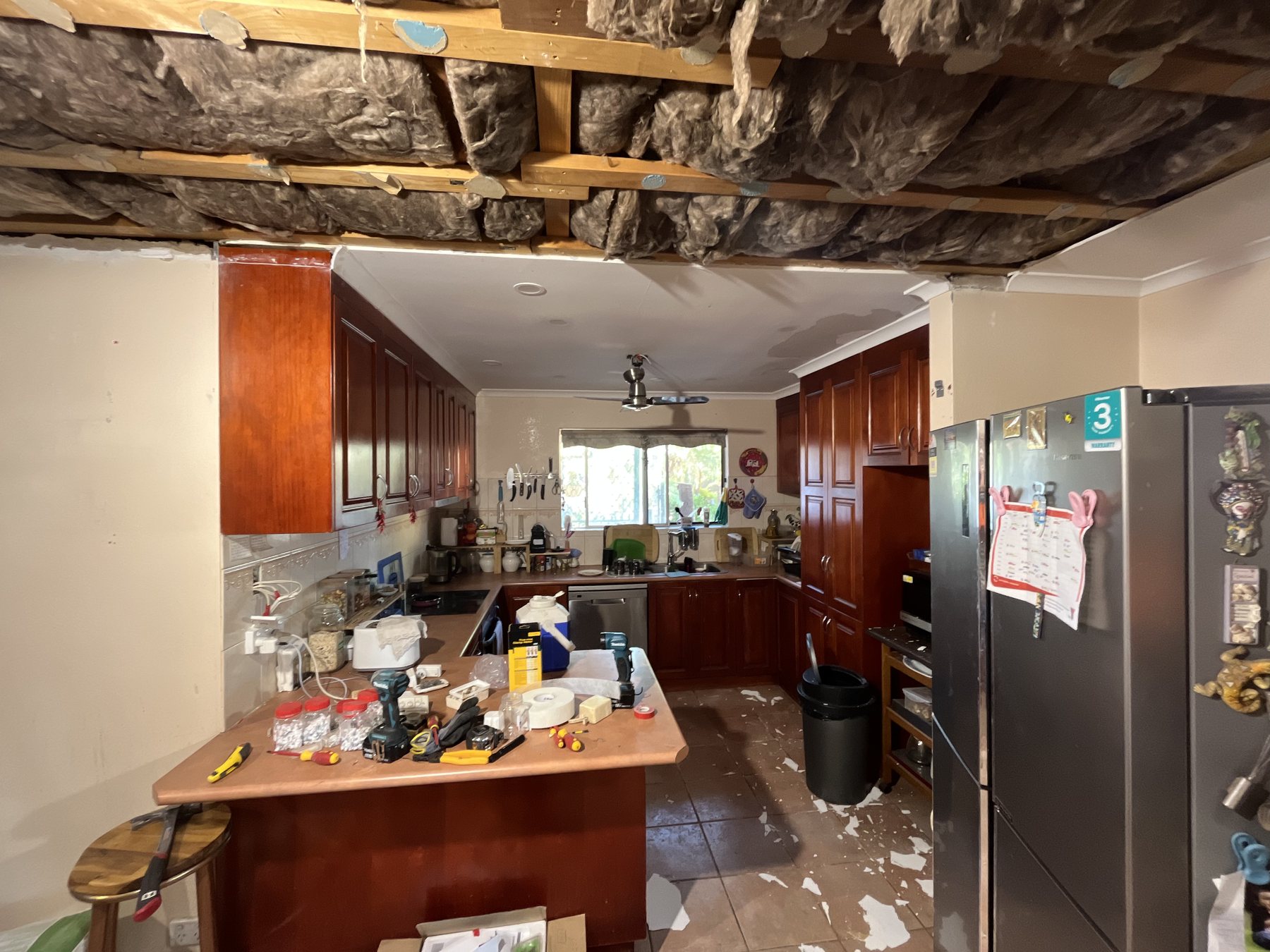 Ceiling down, roof frame and old insulation exposed.